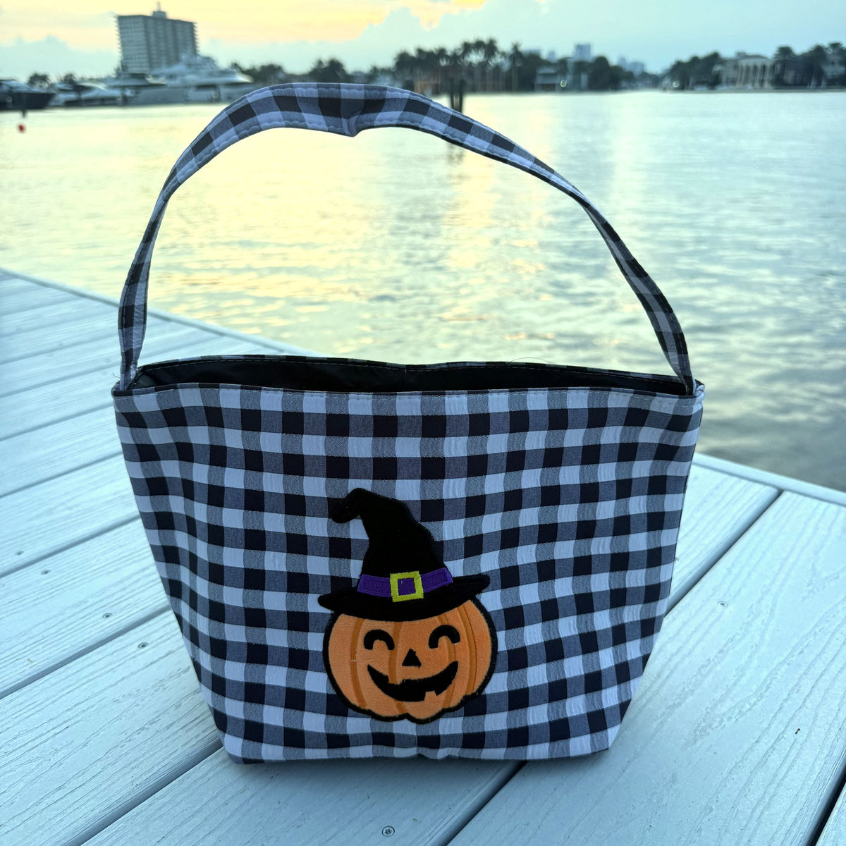 Black gingham basket with a pumpkin wearing a witch hat