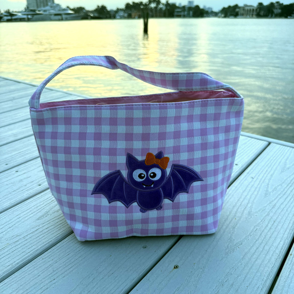 Pink gingham basket with a purple bat wearing an orange bow